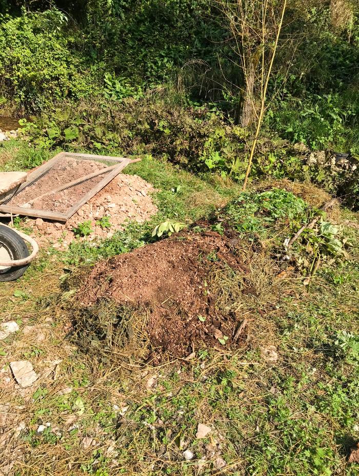 Sieving the clay dirt with an old cupboard screen