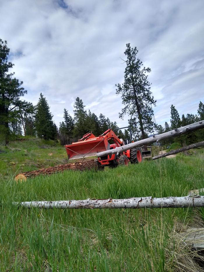 Fred dragging a log down the volcano with the tractor