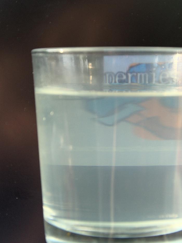 A glass of the water with sun from the left.