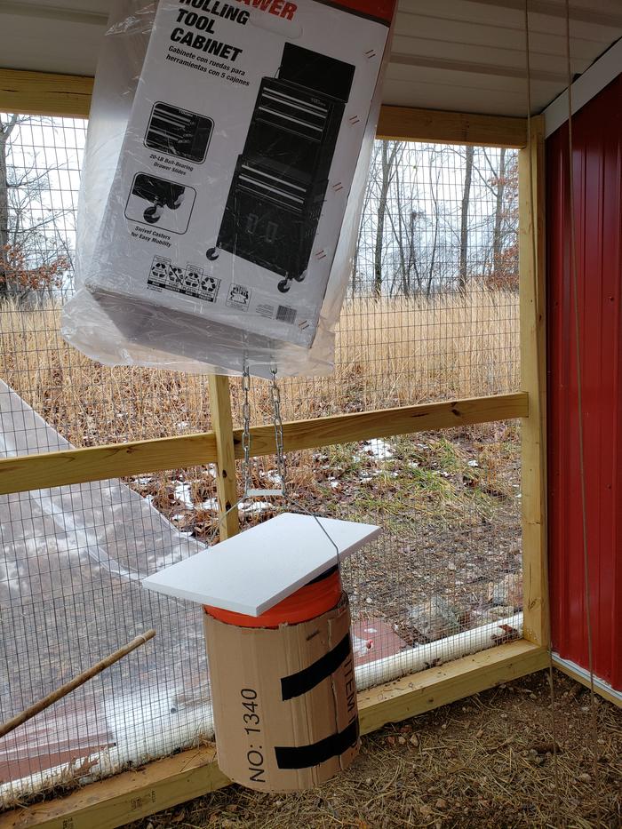 Plastic bag covered box threaded into chain first, then bucket hung on chain, styrofoam covering bucket