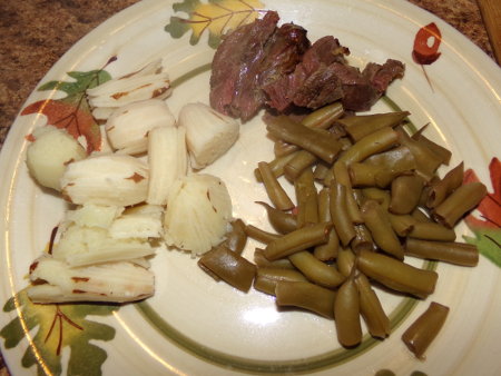 Boiled groundnuts, homegrown home-canned green beans, and home harvested chevon.