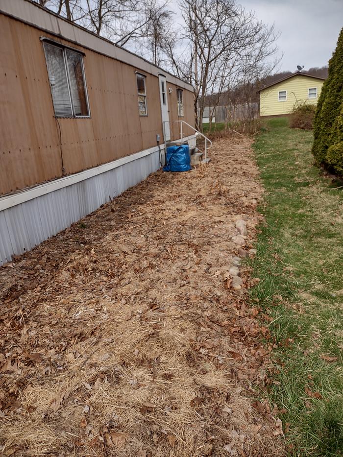 permaculture-side-garden-bed-covered-with-fall-leaves-and-hay