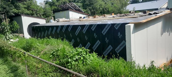 waterproof sheeting on the outer walls of a hobbit house