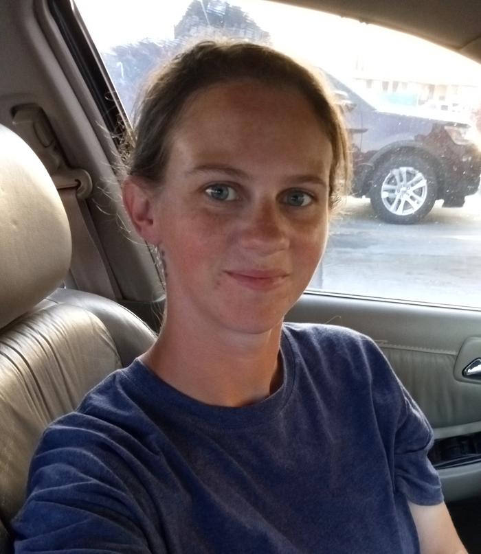 Young woman sitting in a car with her hair in a bun