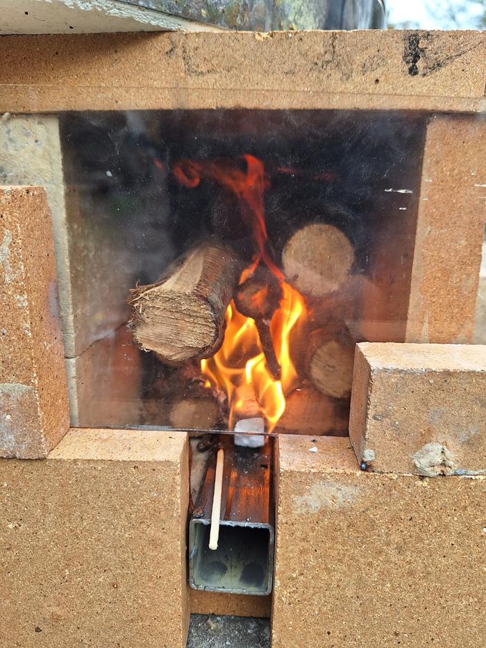 Fire in a riserless rocket stove with glass