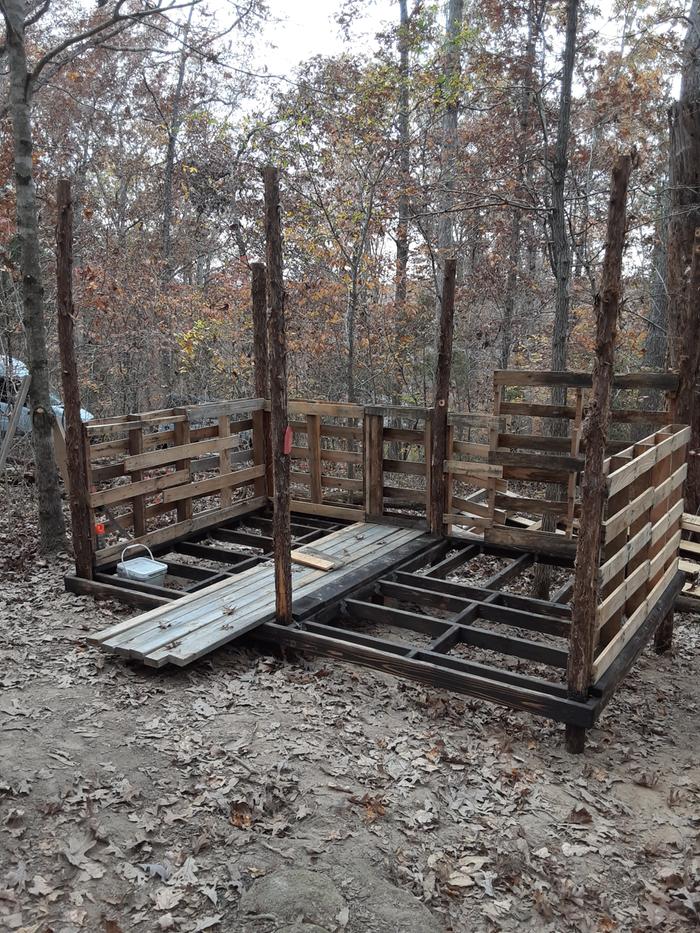 poles and pallets as a light clay straw cabin begins construction