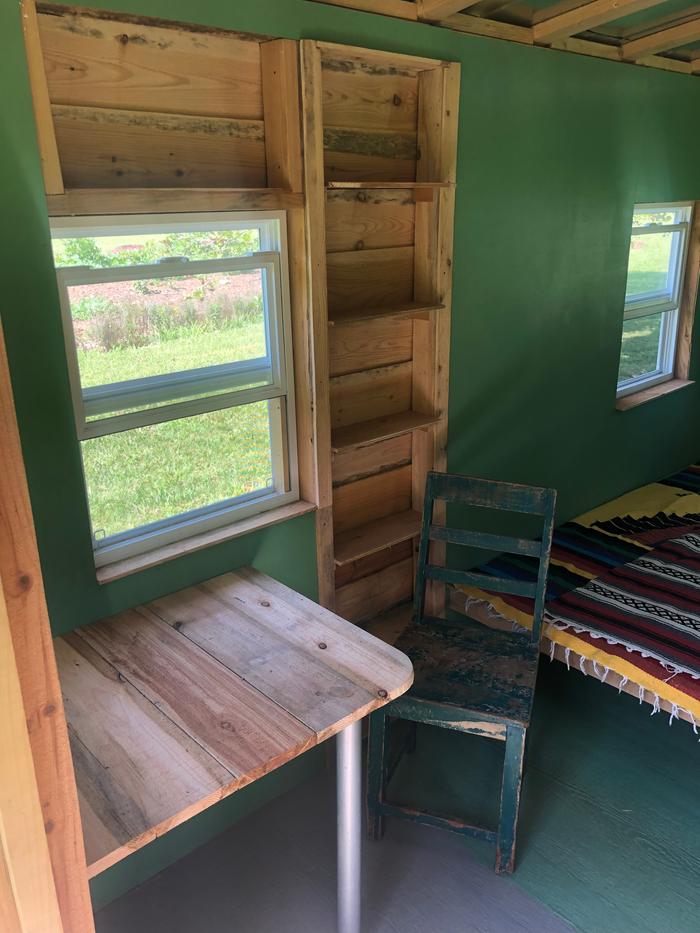 Tin house with bed, bookshelf and table