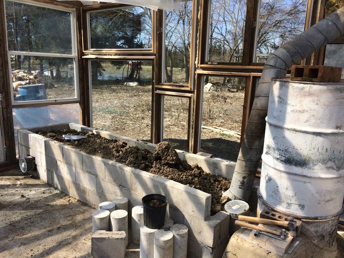 A rocket mass heater in a greenhouse