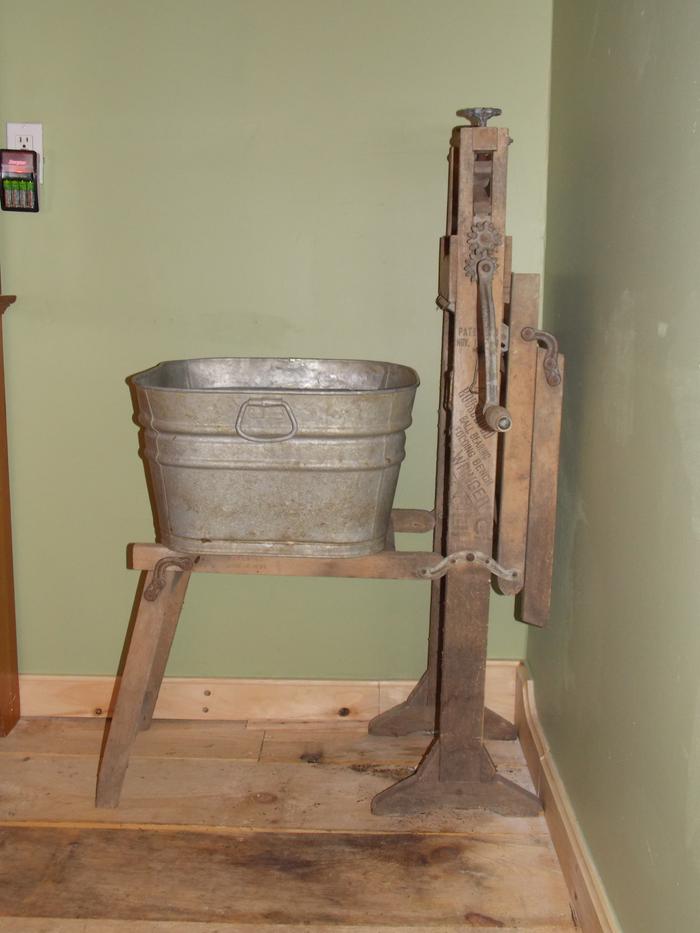 In a real washing situation the other half would be unfolded and the clothes would go from one soapy galvanized tub, through the hand cranked wringer, to the other clean water rinsed galvanized tub.