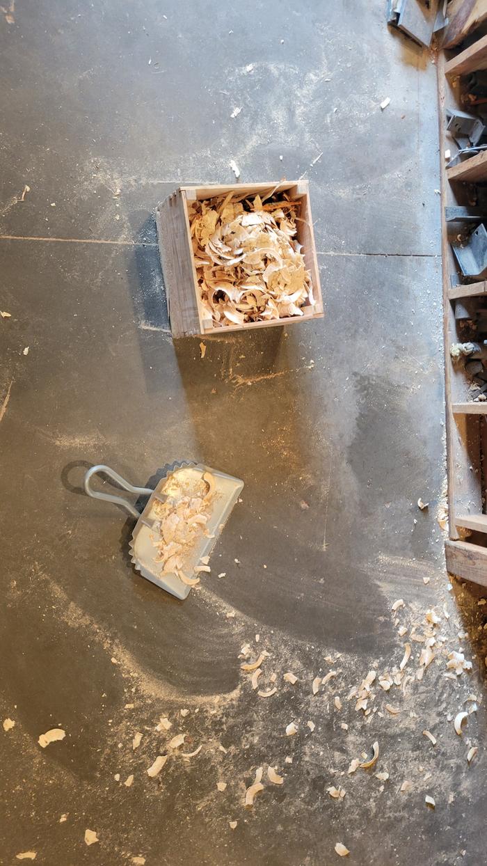 Sweeping wood curls into a RMH candy box