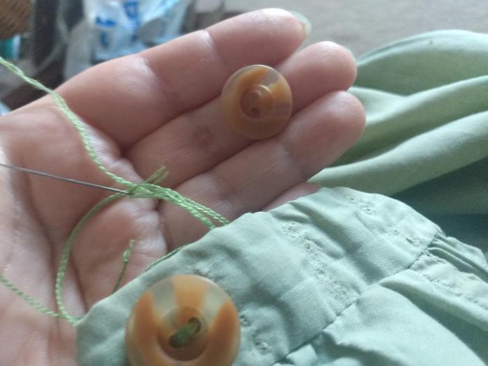 Cotton thread, needle and a button 