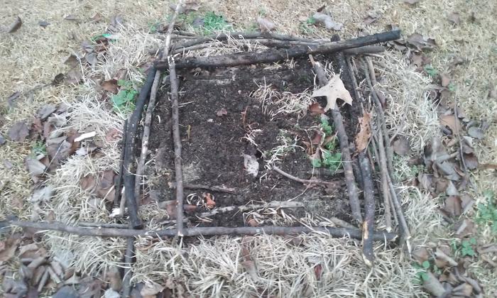 Laying sticks around the outside of a mini hugel