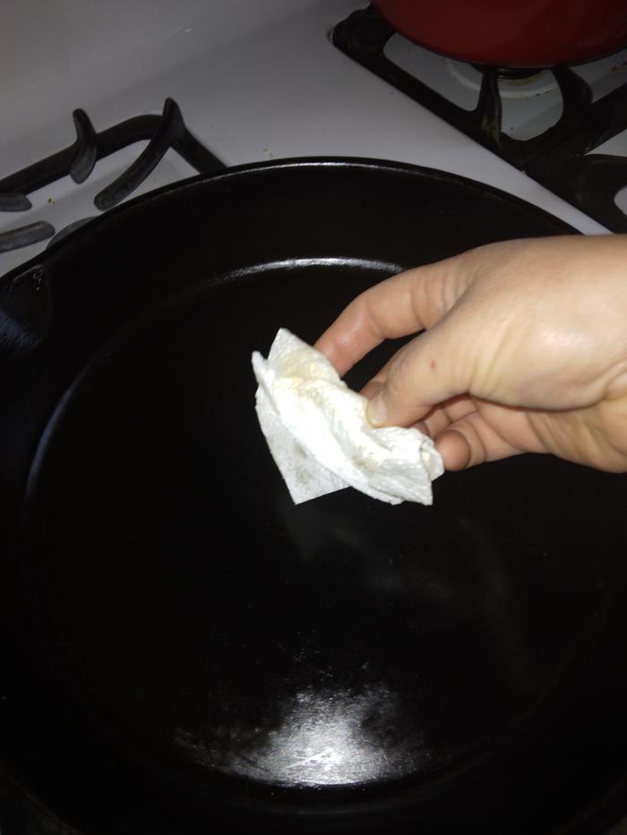 Cleaning the pan by wiping with a paper towel (later used as fire starter)