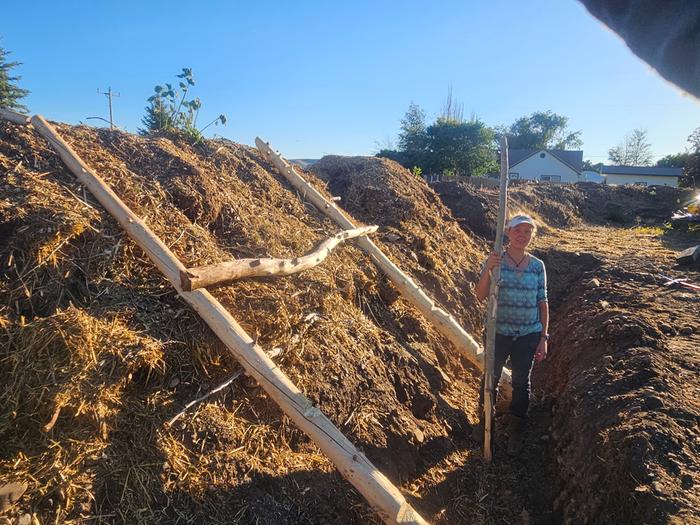 I am holding the pole in the trench, and it is not quite as tall as the hugel bed, so the bed is taller than 7 feet from bed to trench floor