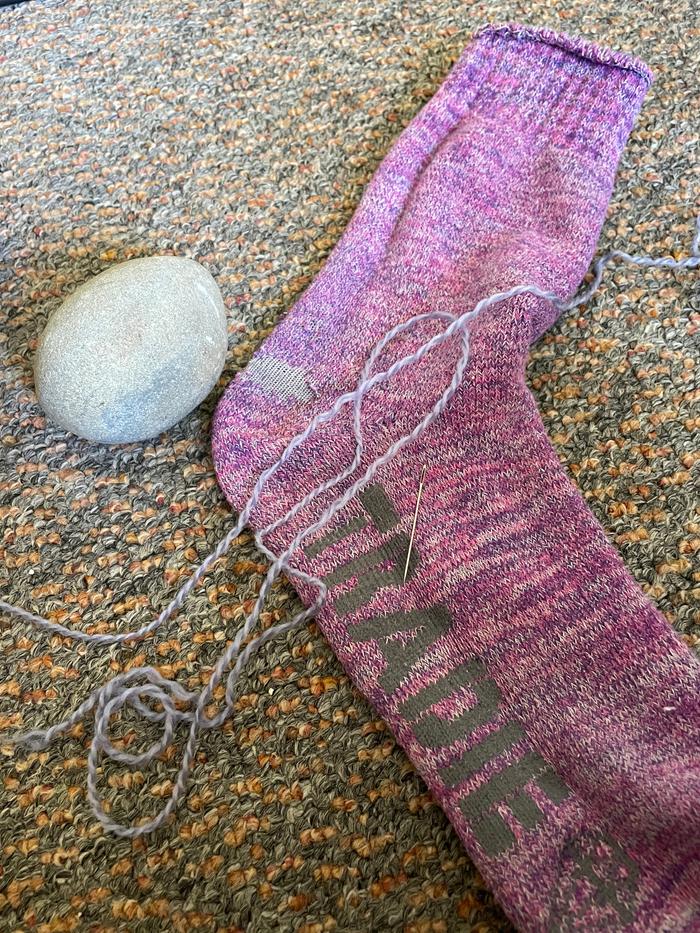 Holey sock, yarn, and rock used instead of darning mushroom thingy