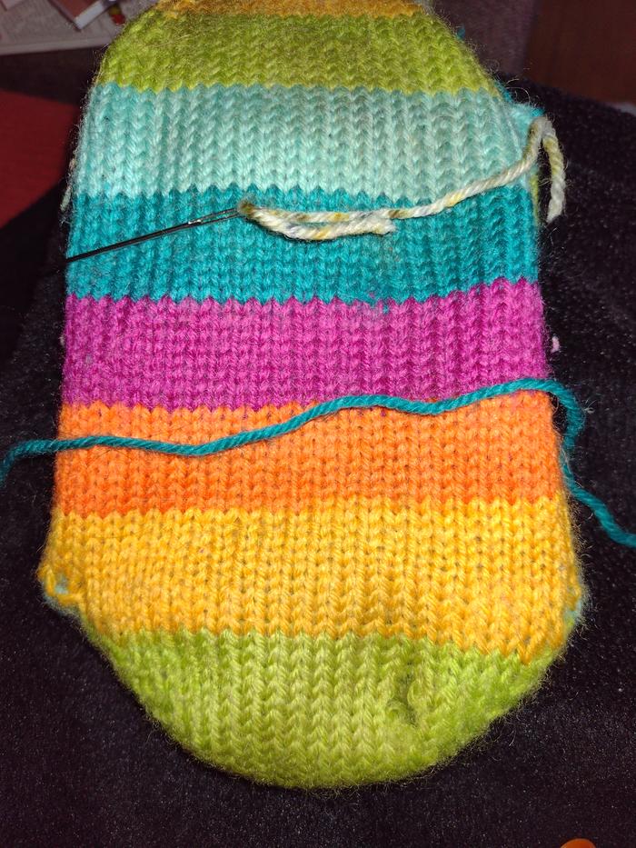 Sock with holes, darning needle and yarn