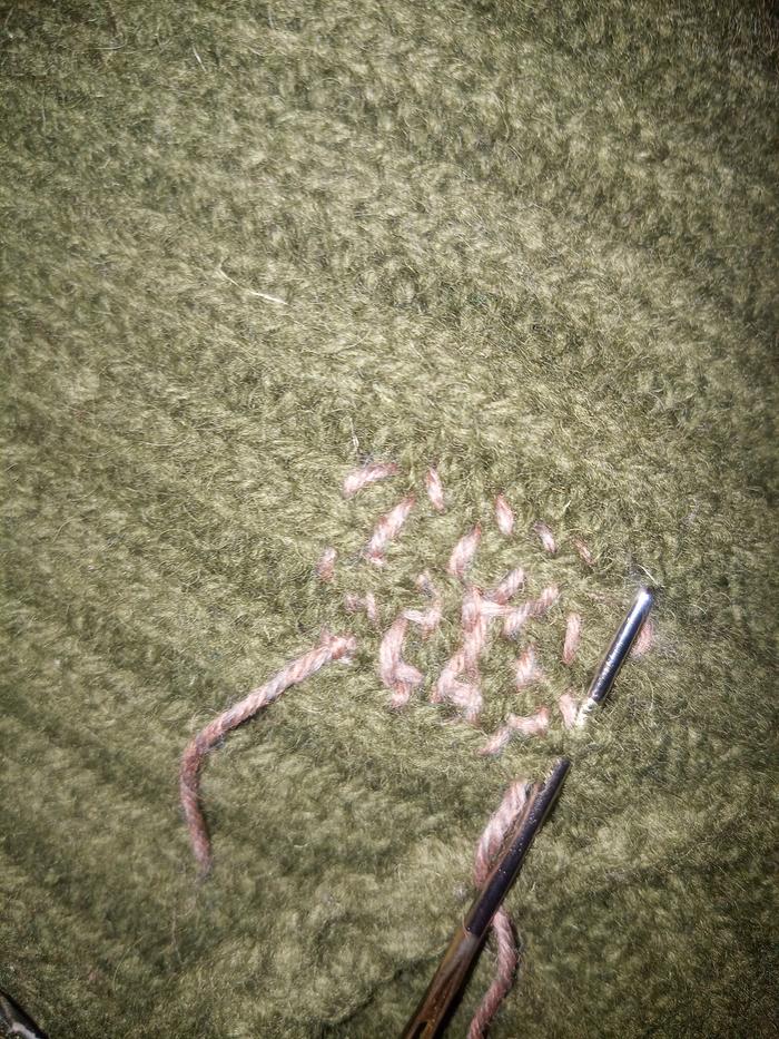 hand darning a hole in a sweater