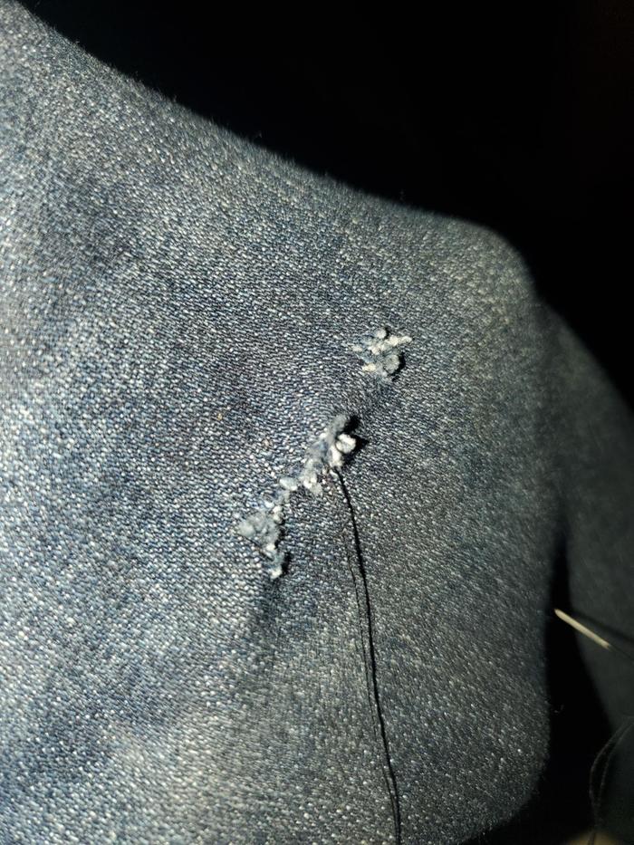 hand mending a hole in jeans