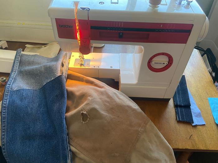 machine mending a hole in overalls