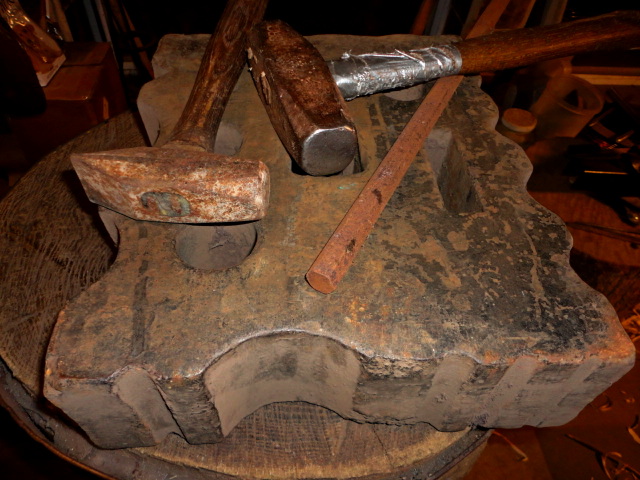 Some hammers for forging, my swage block, and the scrap hex rod to be tapered into a wedge.