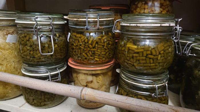 Fermented jars with garlic scapes in storage