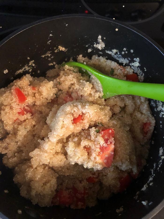 cooked quinoa with fresh tomatoes, olive oil, and salt and served with wild crispy fried Atlantic salmon