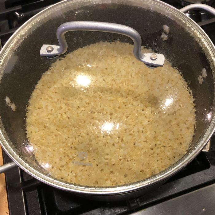 I can no longer see that it’s simmering because the water has retreated beneath the rice, but it’s steaming. 