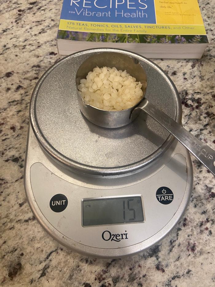 weighing beeswax pellets for salve making