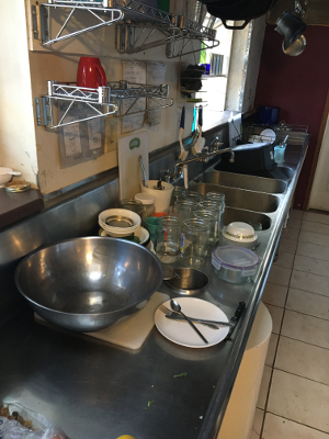 The sink counter with the rest of the dirty dishes