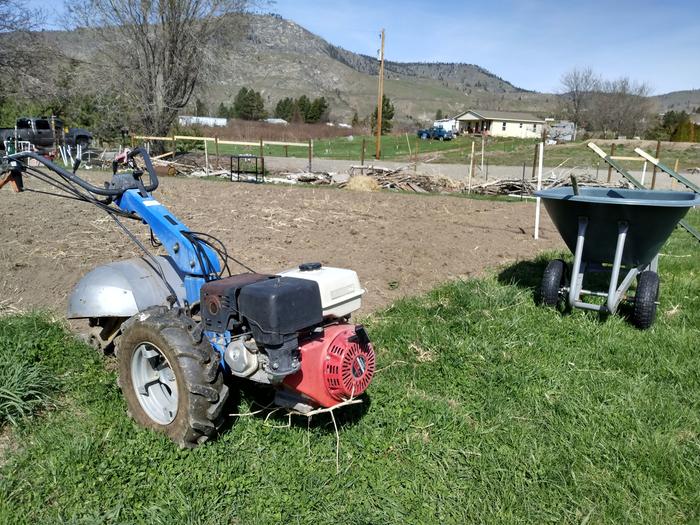 tiller, wheelbarrow, and garden area