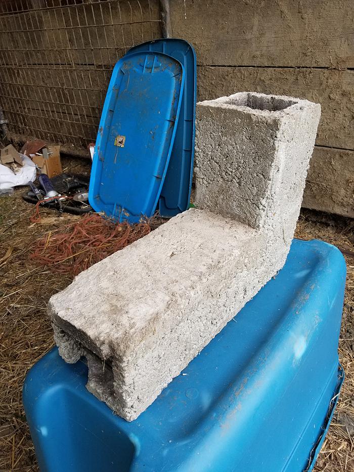 small l shaped rocket stove sitting on a plastic box