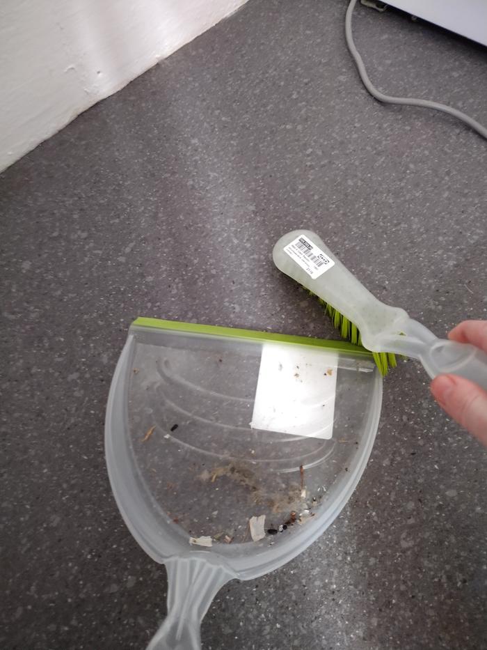Sweeping up the dust and other things that have been caught behind the fridge