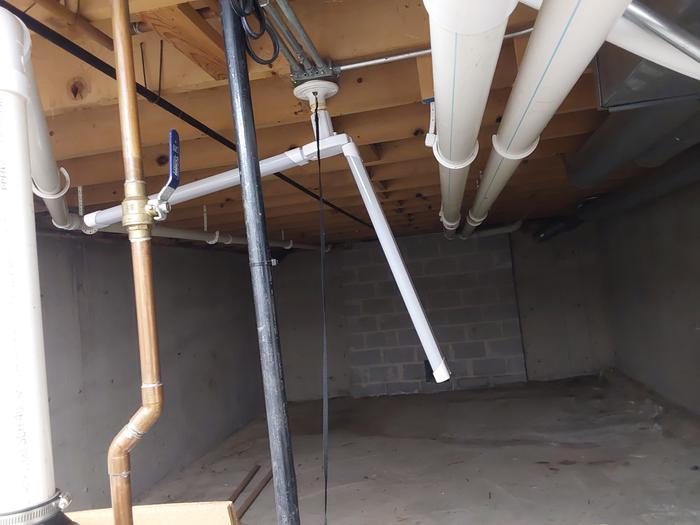 The single Edison base fixture in the utility space where the furnace and water heater live