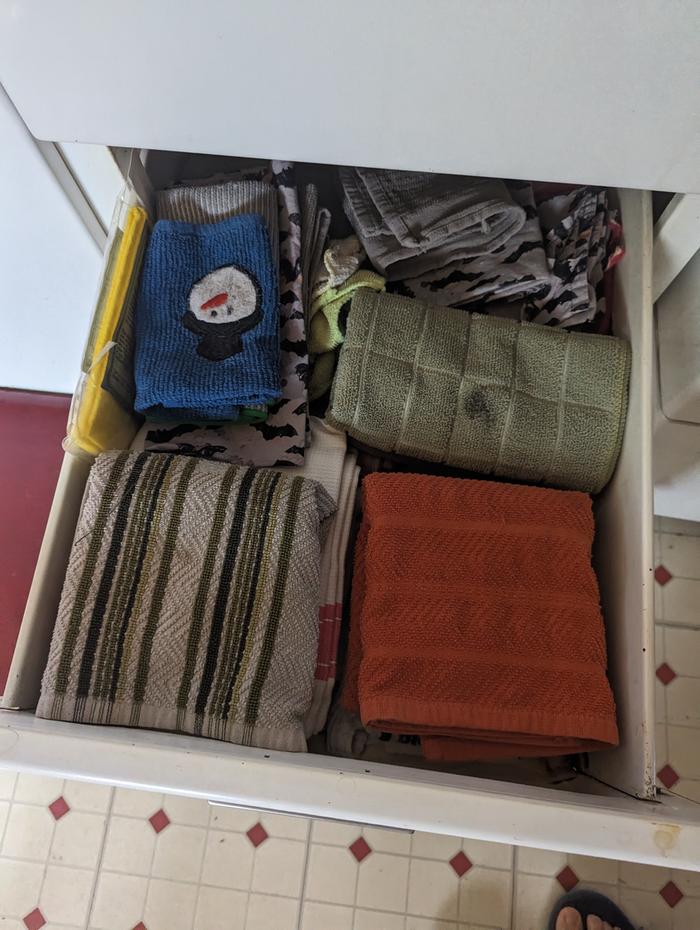 The clean napkins are stored in the drawer with the towels and rags.