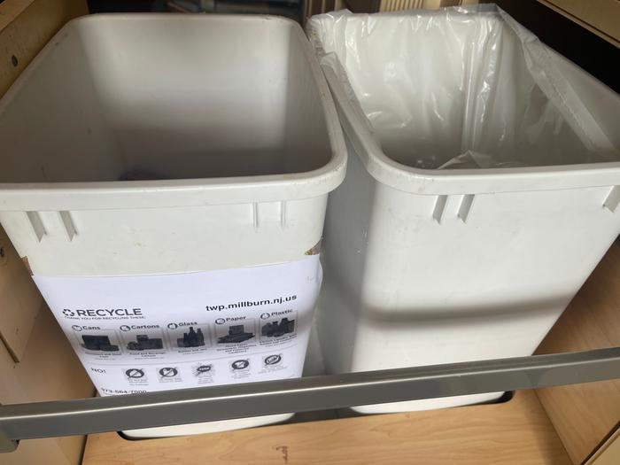 Kitchen bins with label describing recyclable material