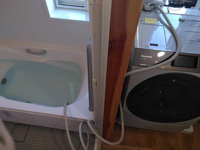 Hose attached to washer and placed in bath water