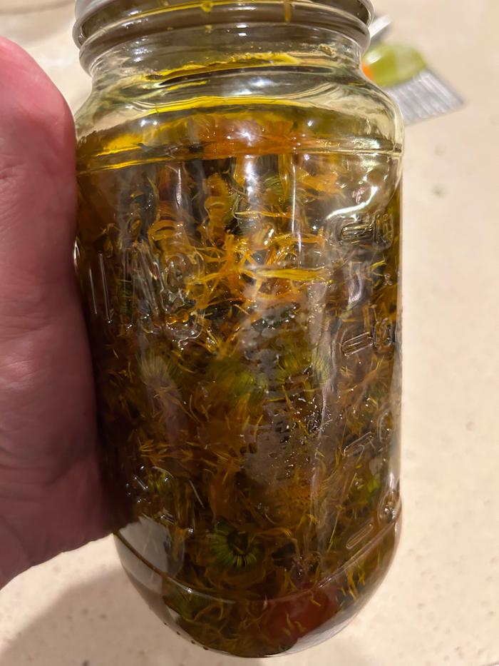 Jar full of dried blossoms and olive oil 