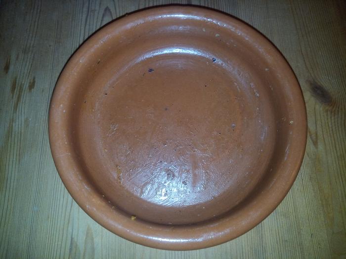 Oily terracotta dish after fried eggs