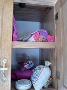 clean rags thrown into cluttered cabinet 