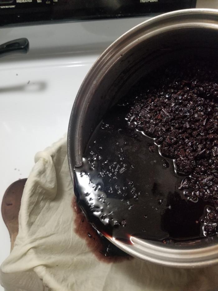 straining the syrup into a bowl with a metal sieve and damp hanky