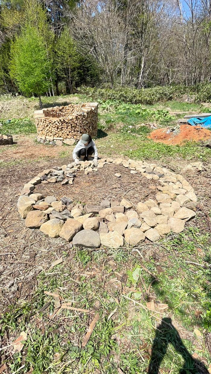 Laying out stones to keep wood off the ground