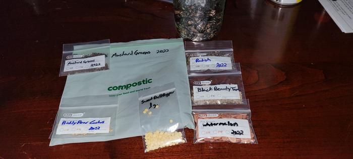 a collection of some of the seeds in their storage packets and jar