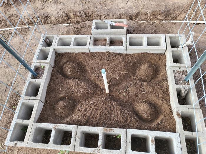 Garden bed with riser showing the riser and mini-swales of sorts before filling with sand/rocks