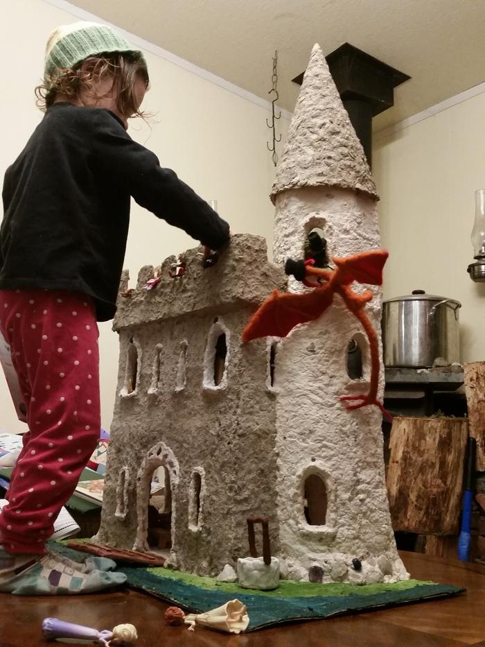 toddler child playing with homemade dollhouse castle