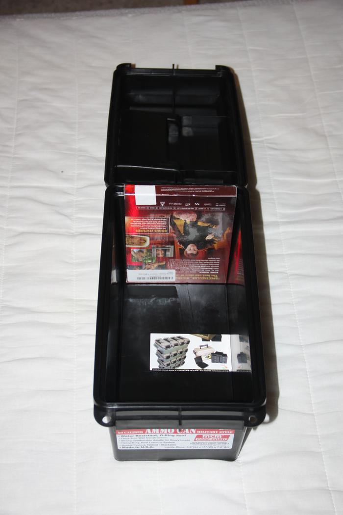 Ammo can open with a DVD case inside for scale