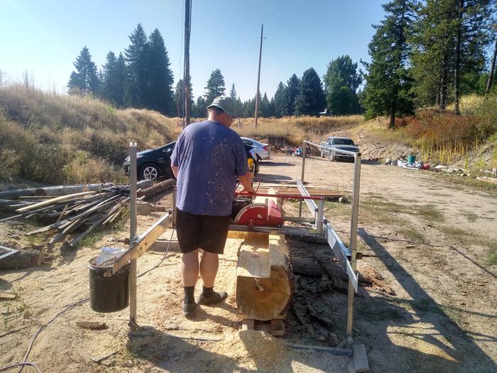 Rodney running the saw mill (after he fixed it)