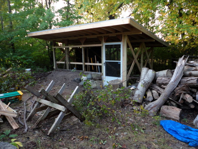 Exterior shot with a couple piles of branches waiting to be woven in.