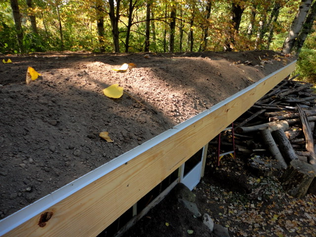 A few days and many wheelbarrow loads later the roof has several inches of topsoil.