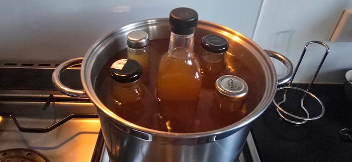 Elderflower cordial bottles in waterbath