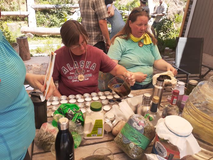 Pouring arnica salve into containers 